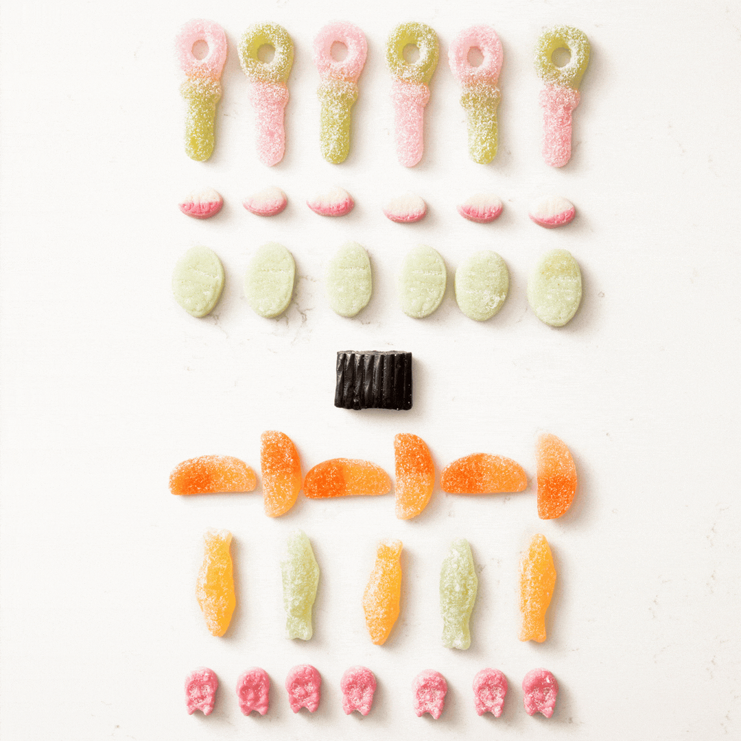 Rows of colorful vegan candy pieces neatly arranged on a white background in a visually appealing pattern