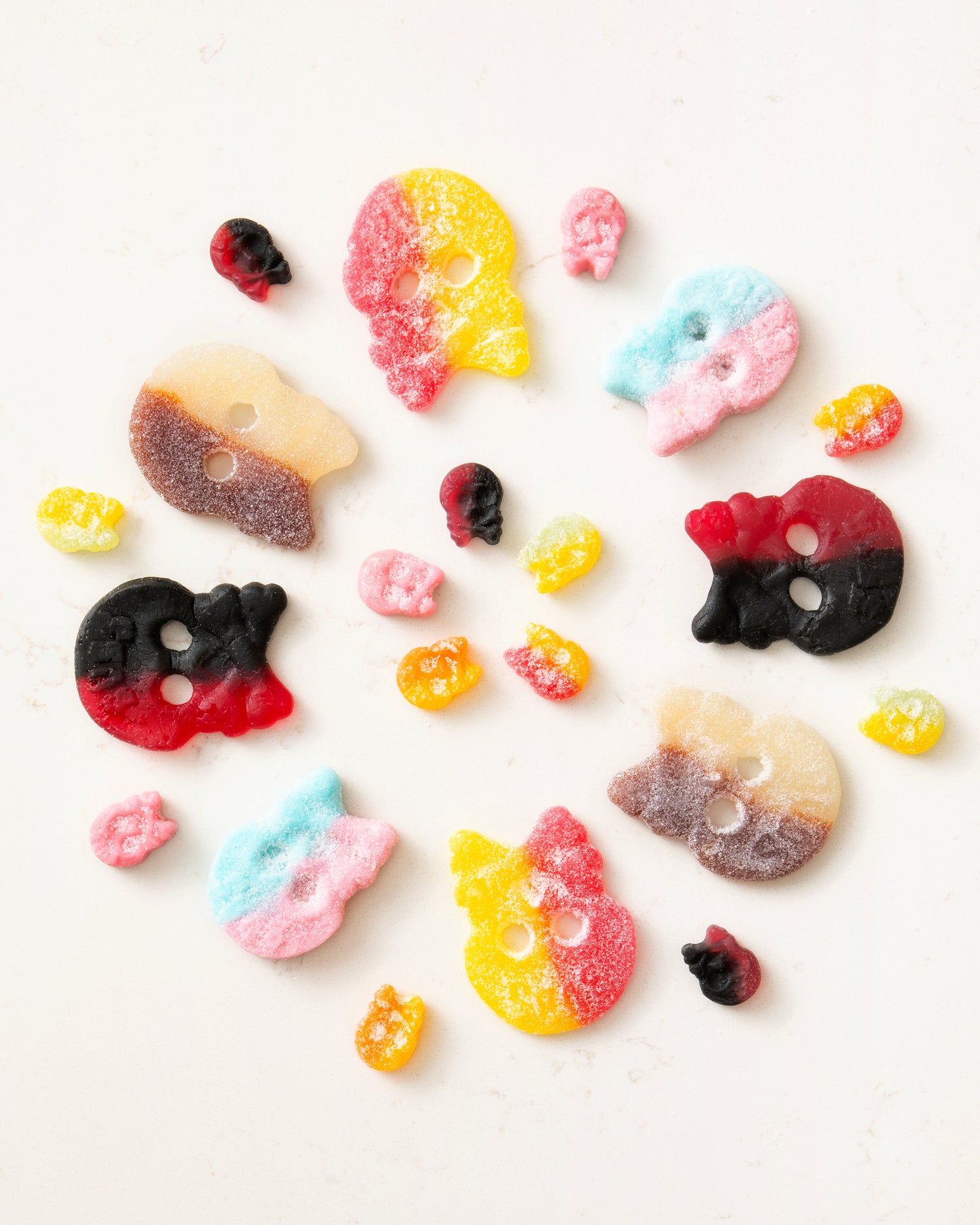 Colorful sugary candy skulls and gummy shapes arranged on a light surface showcasing vegan candy mixes